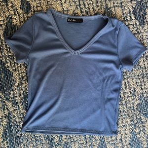 This is a cute, trendy, and stretchy blue shirt! It has a bit of a cropped fit.